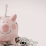 A piggy bank surrounded by coins from a person wondering, can you open a bank account with bad credit?